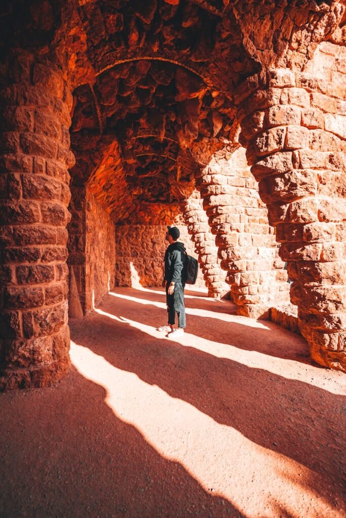 Man with a Backpack Standing in the Grotto in Park Guell in Barcelona, Spain