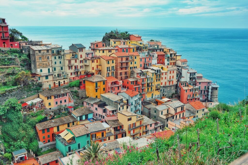 multi-colored village on mountain near body of water