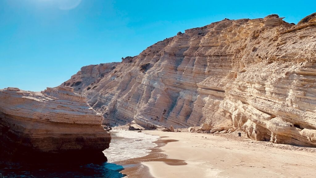 brown rock formation near body of water during daytime