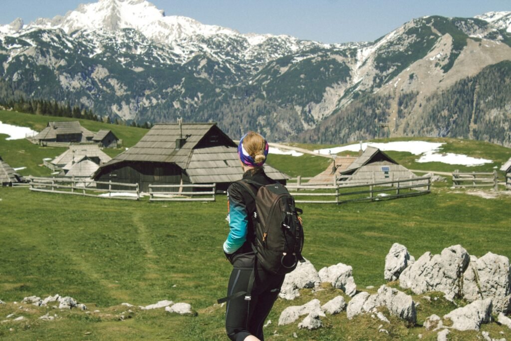 A person with a backpack standing on a grassy field