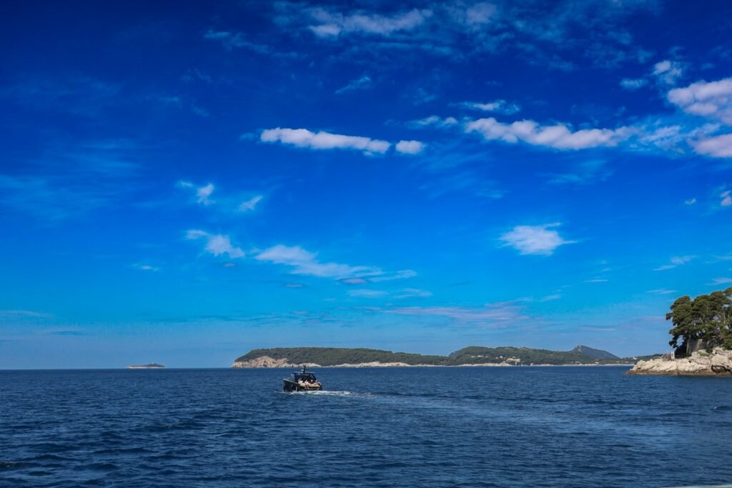 a boat traveling on a body of water near a small island