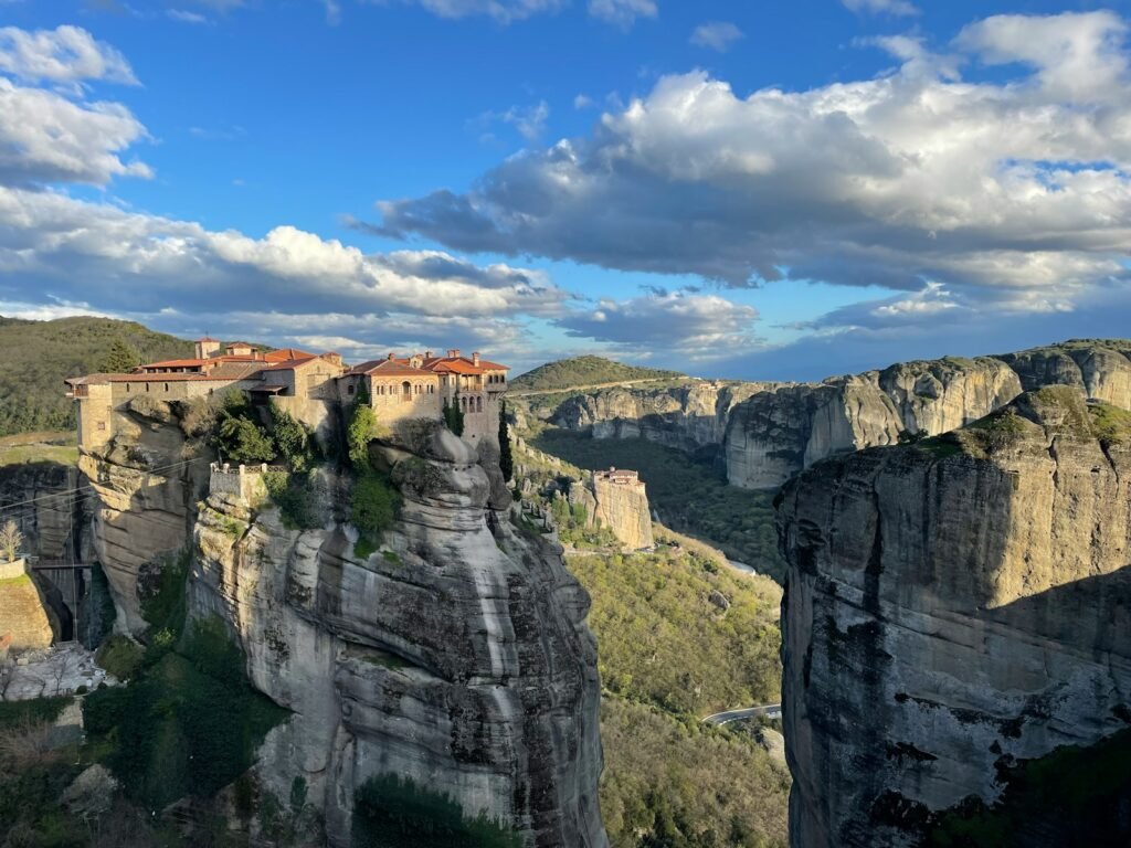 a castle perched on top of a cliff surrounded by mountains