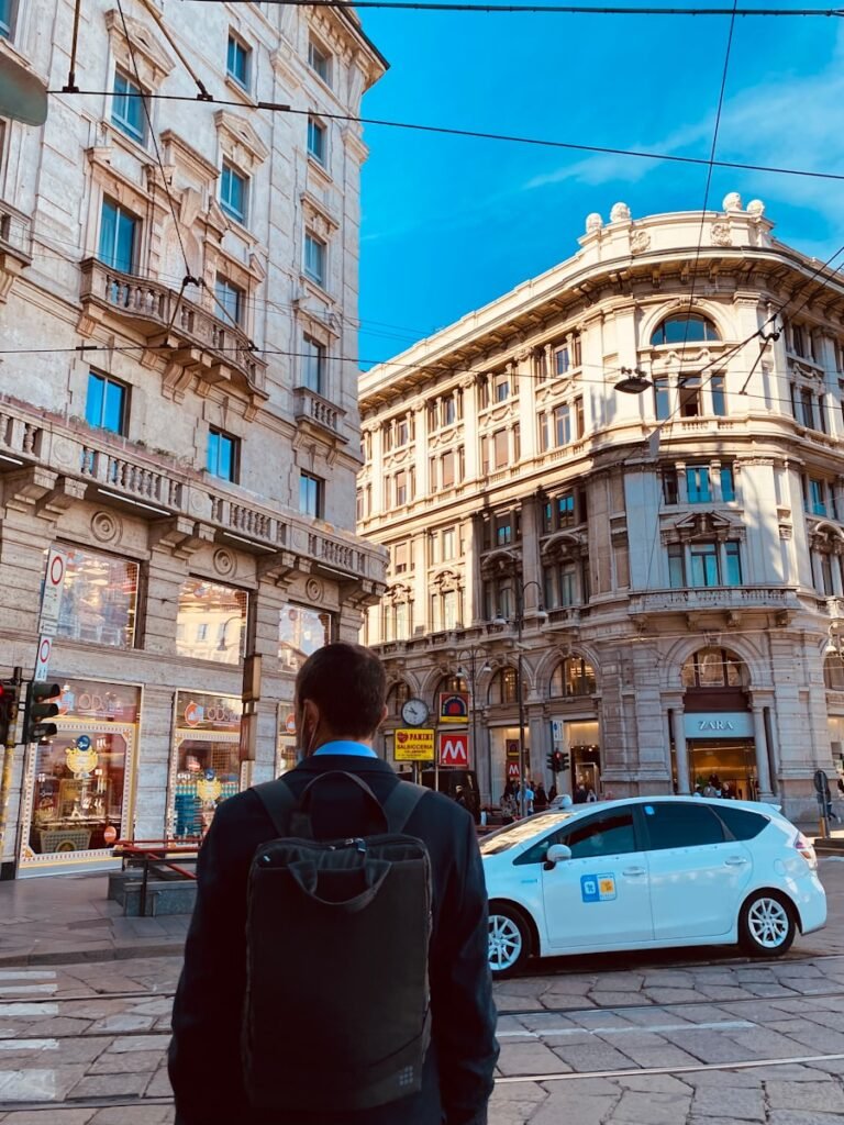 a man walking down a street next to tall buildings