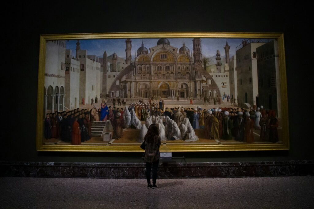 a woman standing in front of a large painting