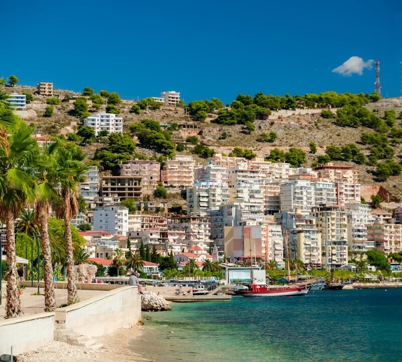 a beach with a city on the other side of it