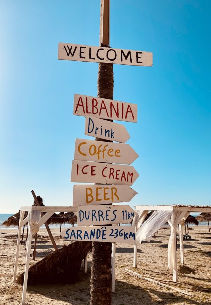 brown wooden welcome to the beach signage