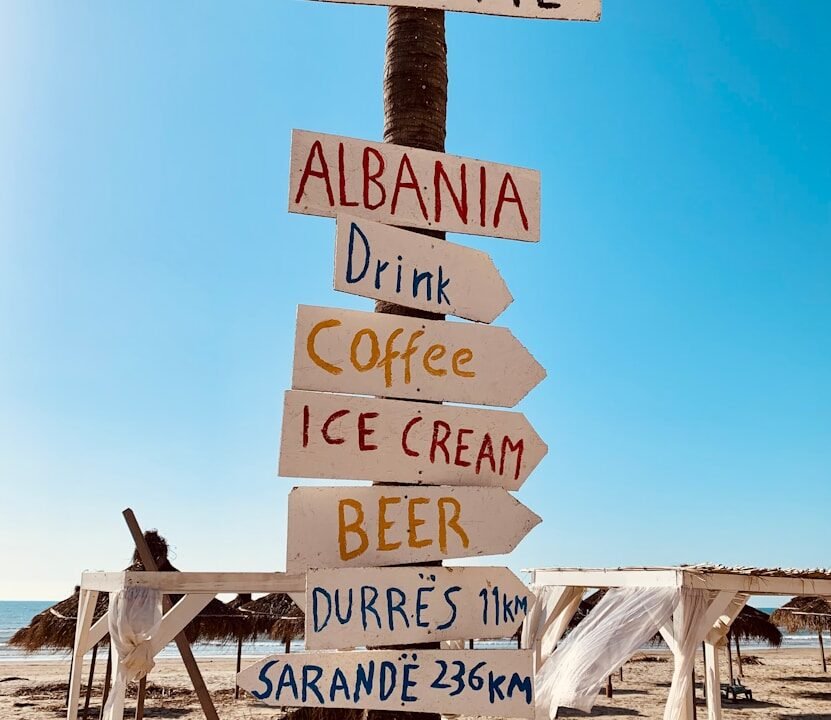 brown wooden welcome to the beach signage